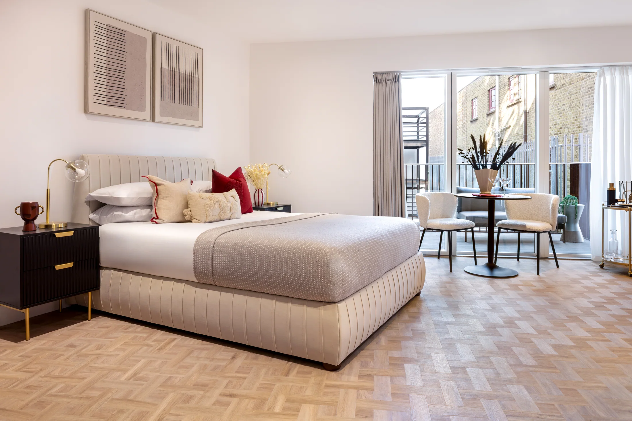 STOK styled sleeping area with neutral bed linen, bedside tables and rich berry accent cushion