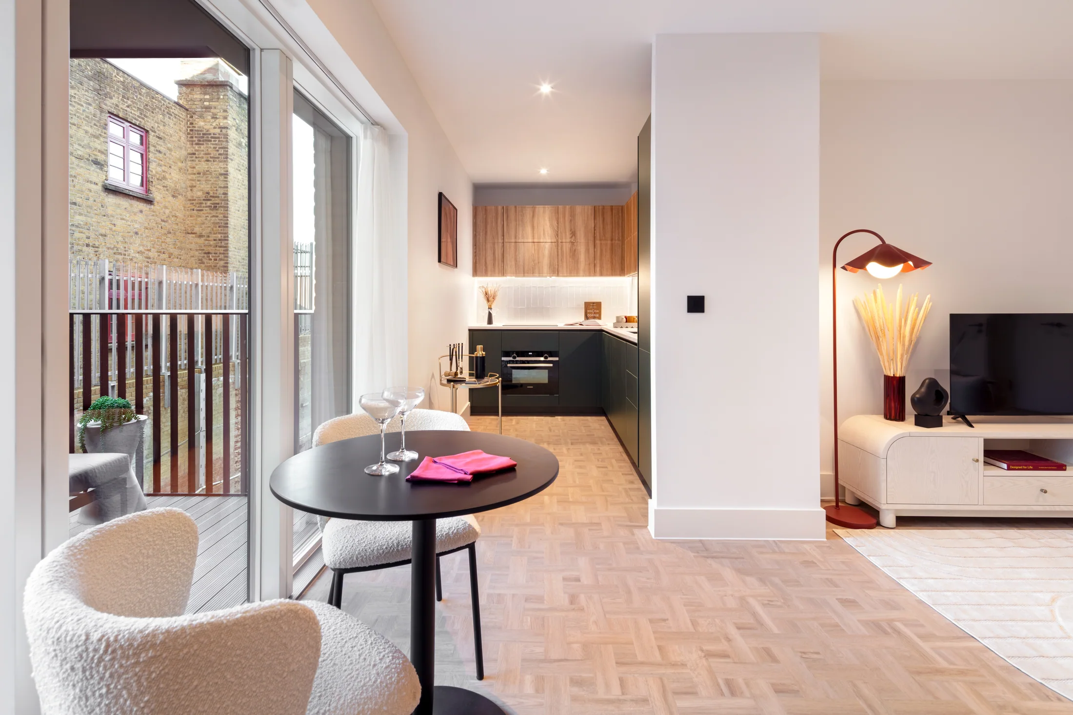 Compact dining setting close to the balcony, showing the transition to the kitchen and living area